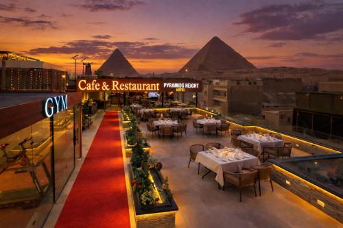 a restaurant on the roof of a building with the pyramids at Pyramids Height Luxury Wing in Cairo