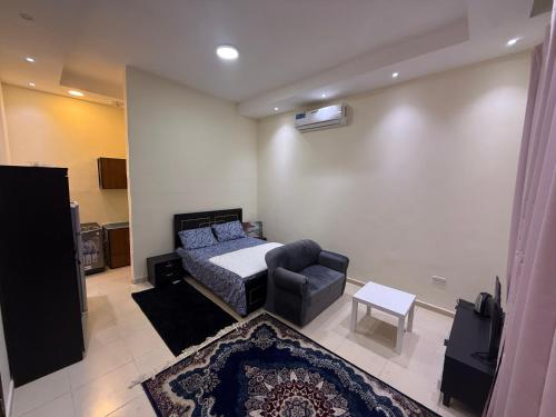 a bedroom with a bed and a couch and a chair at Abu Dhabi Cozy studio in Abu Dhabi