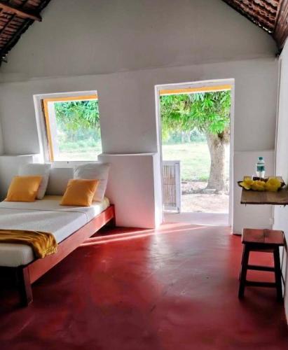 a bedroom with a bed and a large window at MBOTY Village in Vohemar