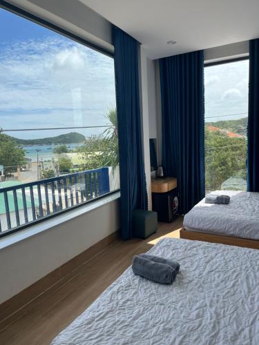 a bedroom with two beds and a large window at HOTEL vùng vịnh in Cầu Sông Kinh