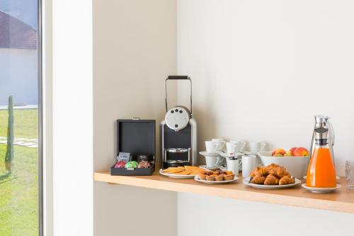 a counter with plates of food on a shelf at Best Western Plus Hotel Divona Cahors in Cahors