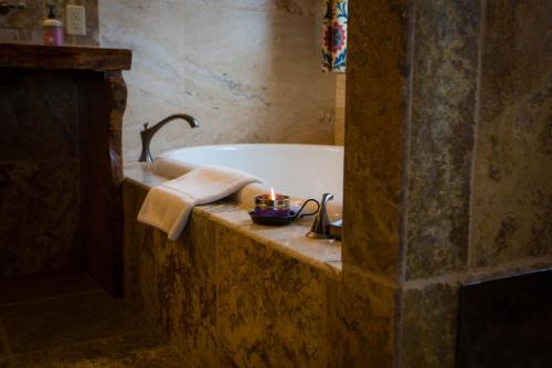 a bathroom with a bath tub with a candle in it at Baycrest Lodge in Homer