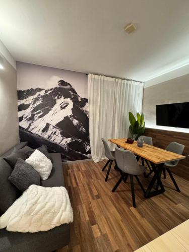 a living room with a couch and a table with a mountain mural at Lilli apartment in Aprica