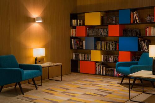 a library with two chairs and a book shelf filled with books at Best Western Plus Hotel Divona Cahors in Cahors
