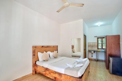 a bedroom with a bed with white sheets and a ceiling at Hotel Calangute bay in Calangute