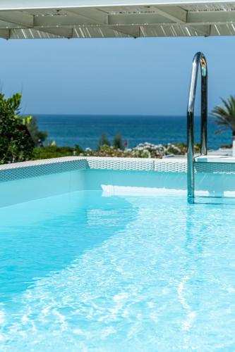 a swimming pool with a water slide in front of the ocean at Savoy Hotel & Spa - Preferred Hotels & Resorts in Paestum