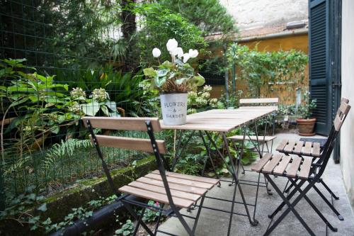 un tavolo e sedie con una pianta in vaso di The Como Secret Garden a Como