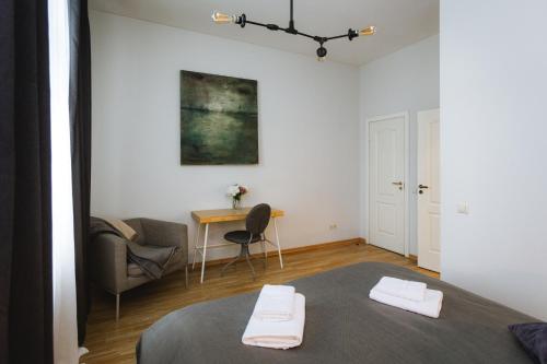 a room with a bed and a table and a chair at Bearsleys Downtown Apartments in Riga