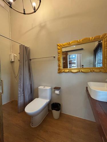 a bathroom with a toilet and a sink and a mirror at Reuan Vilawan Waterfront in Ban Nong Chaeng