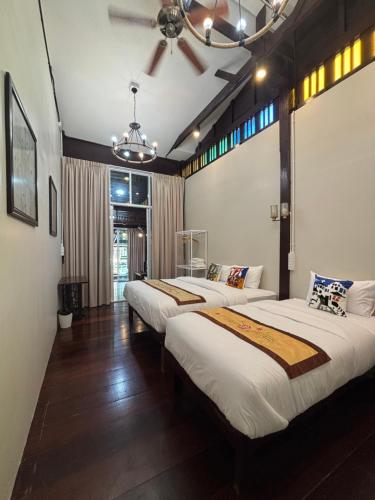 a bedroom with three beds in a room at Reuan Vilawan Waterfront in Ban Nong Chaeng