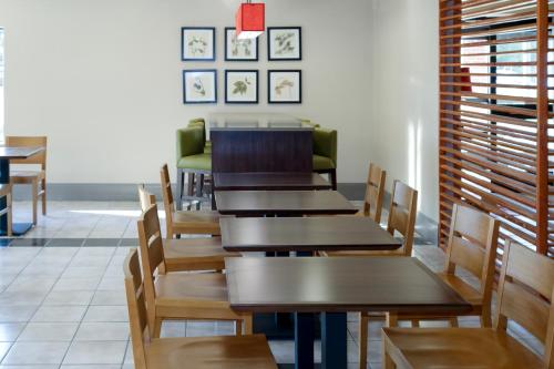 a dining room with wooden tables and chairs at Country Inn & Suites by Radisson, Dahlgren-King George, VA in Dahlgren