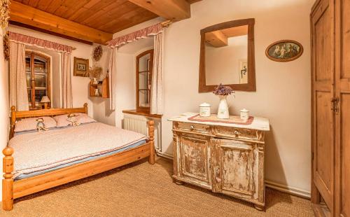 a bedroom with a bed and a mirror and a dresser at Růžová chalupa u Šimánků in Rtyně v Podkrkonoší