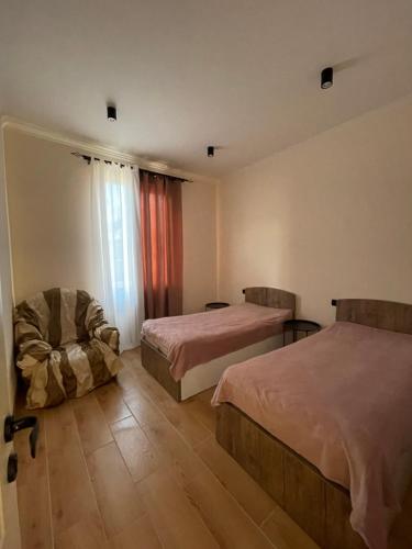 a hotel room with two beds and a chair at Home Kodjori in Kojori