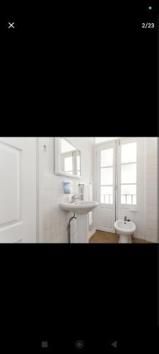 a white bathroom with two sinks and two windows at portochique AL7 in Porto