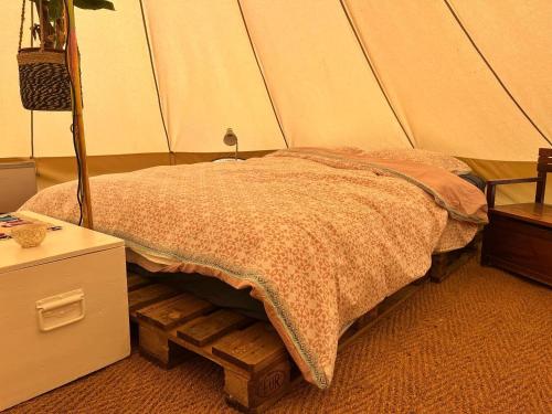 a bedroom with a bed in a tent at Arkeo - Luxury tents and cabins at the river in Nonceveux
