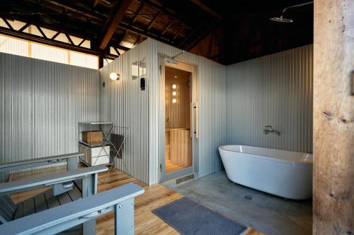 a large bathroom with a tub and a sink at SAUNARF Aoshima in Miyazaki
