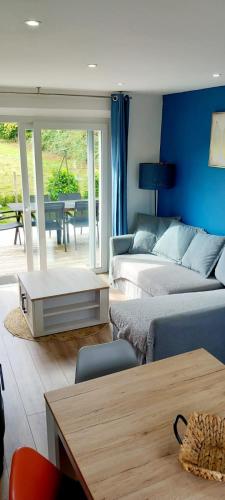 a living room with two beds and a table at Maison l'Escale du port in Berville-sur-Mer