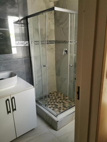 a shower with a glass door in a bathroom at Hotel Redcliff in Redcliff