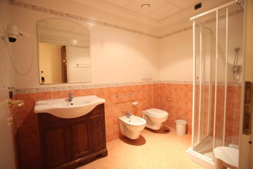 a bathroom with a sink and a toilet and a mirror at Fruit Village Tropea Baia della Rocchetta Soft all Inclusive in Conidoni