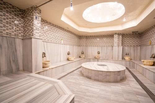 a bathroom with four toilets and a round tub at Casa Solada Cunda Resort & Spa in Ayvalık