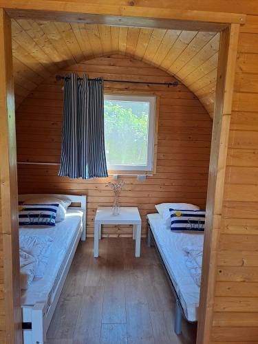 a room with two beds and a window in a cabin at Camping le Kergorz in Plomodiern