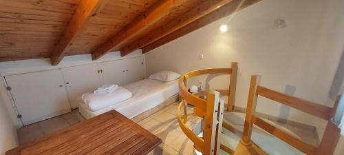 a small room with a bed and a wooden ceiling at Harmony 3 in Artemida