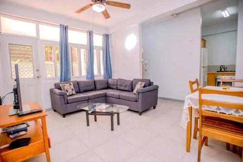 a living room with a couch and a table at Bougainvillea Apartments in Saint Georgeʼs