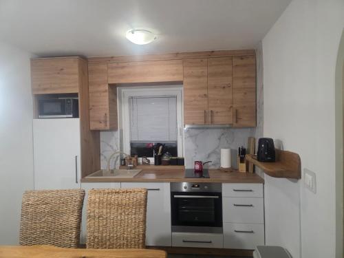 a small kitchen with wooden cabinets and a stove at Apartment Amy in Podčetrtek