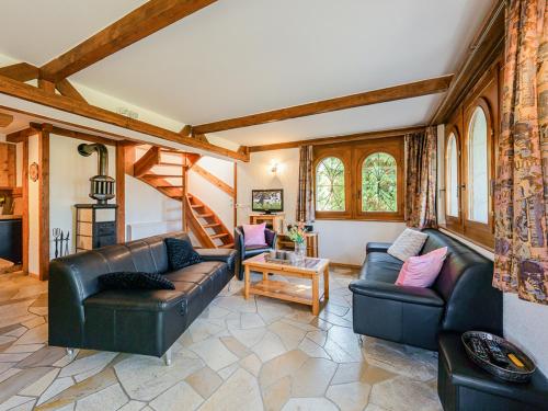 a living room with two leather couches and a table at Chalet Marinette in Icogne