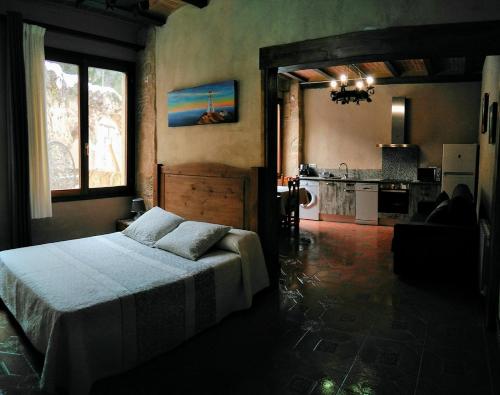 a bedroom with a bed and a kitchen at Estudio El Tosca in Beceite