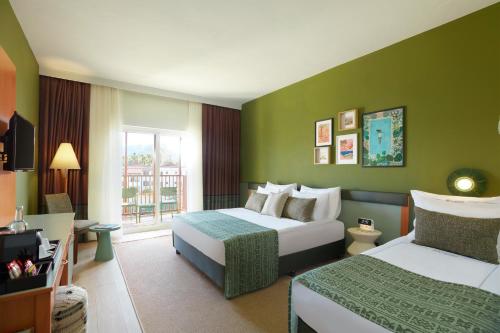 a hotel room with two beds and a window at Corendon Hydros Club Kemer - Ultra All Inclusive in Kemer