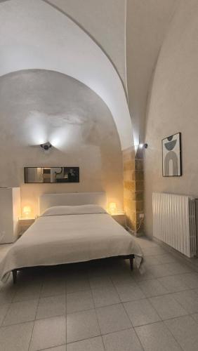 a bedroom with a bed in a room with an arch at Celebes in Brindisi