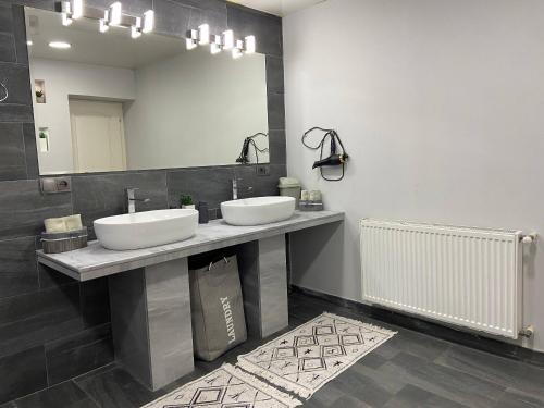 a bathroom with two sinks and a large mirror at Behind the Parliament Building in Tbilisi City