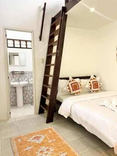 a bedroom with a bunk bed and a bathroom at Surfside Bungalows in General Luna