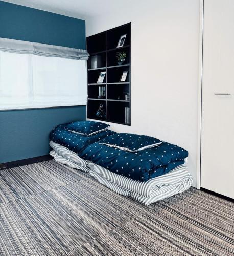 a bed in a bedroom with a blue and white room at Akikawa Koshi 6 プレミアム鉄骨 一棟貸切ヴィラ in Kikutomi