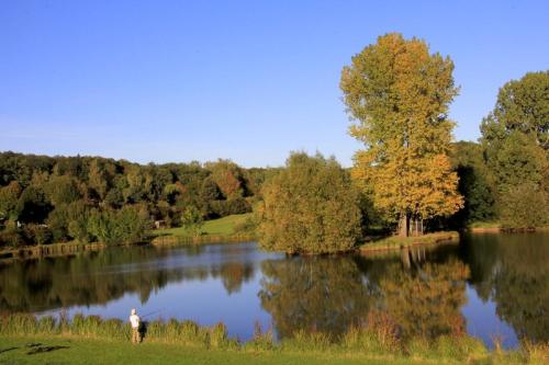 a man standing in front of a lake at Hessen Hotelpark Hohenroda in Hohenroda