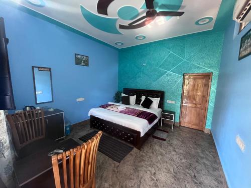 a bedroom with blue walls and a bed and a ceiling at Navya Homestay and Restaurant in Jāmb