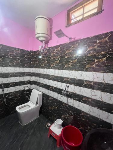 a bathroom with a toilet and a sink at Navya Homestay and Restaurant in Jāmb