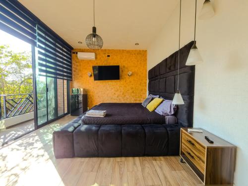 a bedroom with a bed and a leather couch at Suite en Tlaquepaque centro in Guadalajara