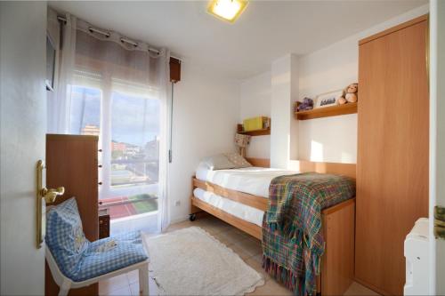 a small bedroom with a bed and a window at LOS RESPIGOS PLAYA in Laredo