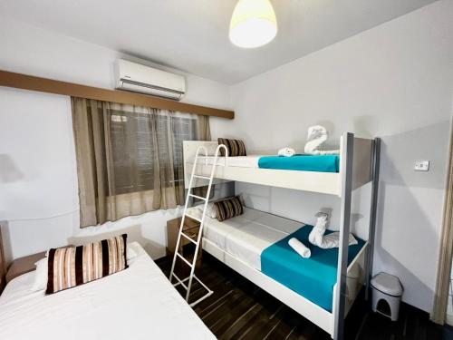 a room with two bunk beds and a ladder at Margarita Napa Apartments in Ayia Napa