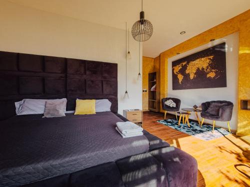 a bedroom with a large black bed and a chair at Suite en Tlaquepaque centro in Guadalajara