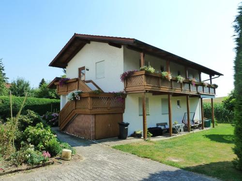 a house with a balcony with flowers on it at Pension Sochor in Aidenbach