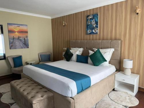 a bedroom with a large bed and a chair at Résidence Hôtelière Océane in Libreville