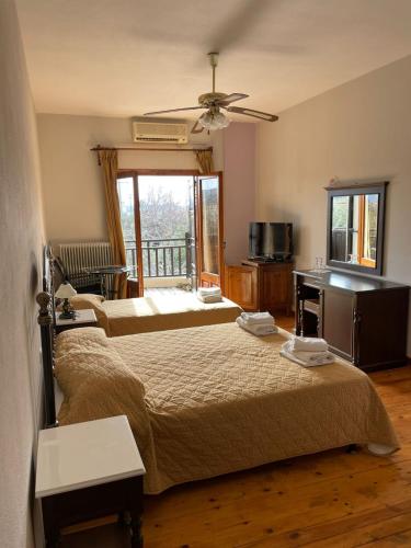 a bedroom with two beds and a balcony at Saily Beach Hotel in Koropi