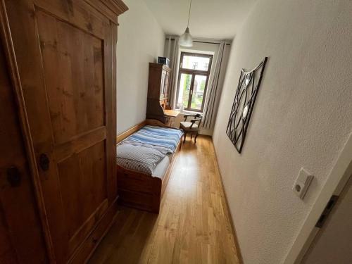 a small room with a bed and a window at Bastians Herberge in Leipzig