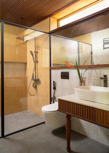 a bathroom with a toilet and a sink and a shower at CardMem Hills View Pool Villa & Resort, Thekkady in Thekkady