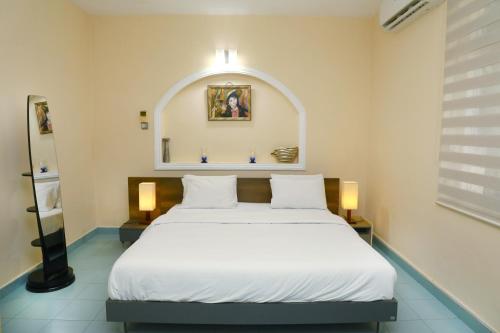 a bedroom with a large white bed in a room at Dehiwala Holiday Villa in Dehiwala