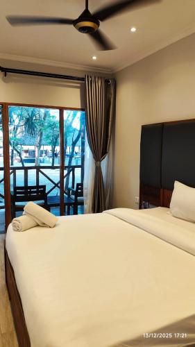 a bedroom with a large white bed and a window at Sunrise Beach Resort in Dar es Salaam