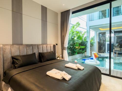 a bedroom with a bed with two towels on it at Indiluxe pool villa in Pattaya South